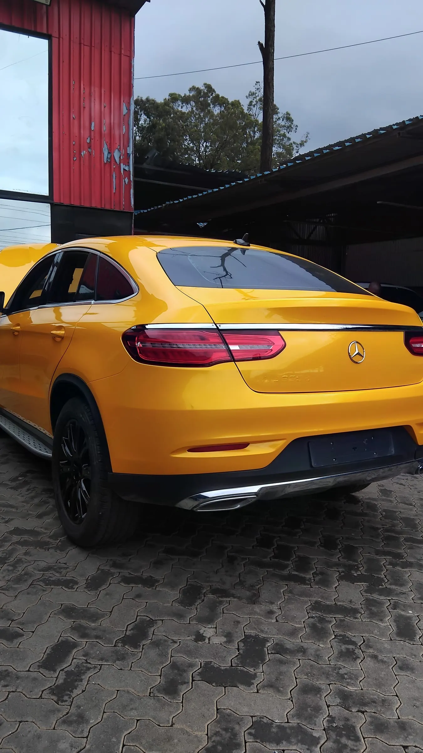 Rear three-quarter view of a Mercedes-Benz GLE Coupe in a gloss gold wrap